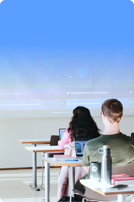 A blue-tinted photograph of healthcare students in scrubs sitting around a conference table engaged in a lively discussion, with a Kahoot! presentation visible on a screen in the background