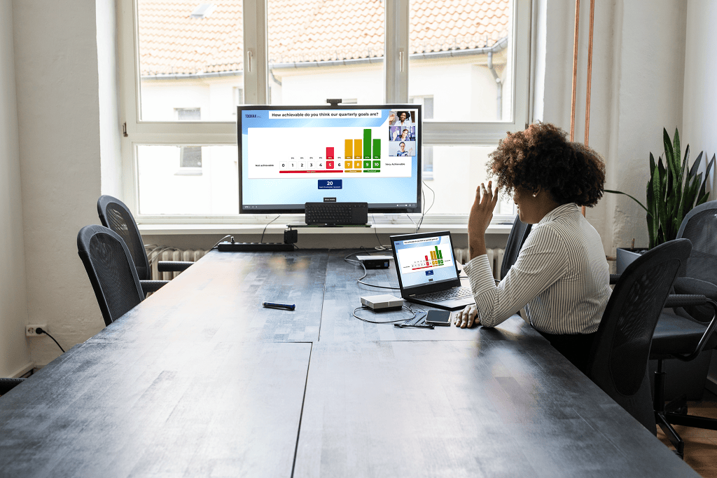 A professional sitting at an office table participating in a kahoot session during a virtual meeting