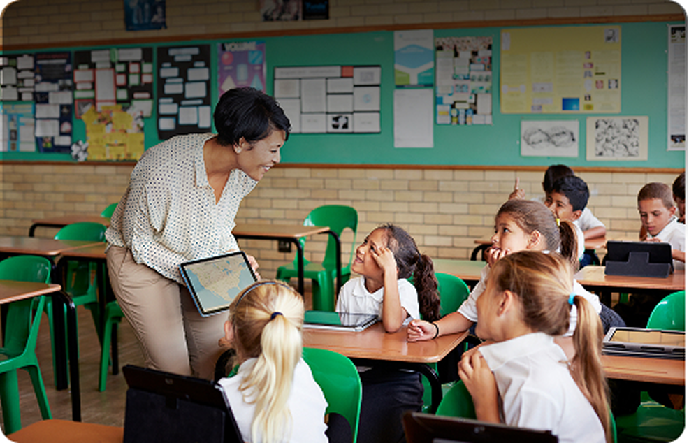 Female teacher in a classroom talking to a group of students